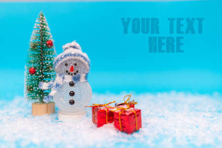 Blank space for your inscription snowman on a blue background with presents.Front view image.の写真素材