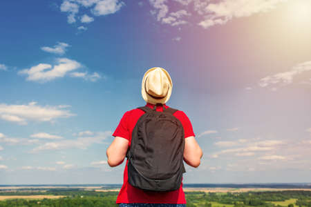 Young man admiring beautiful view of the forest landscape rear view.Young man standing alone summer day outdoor with wild forest on background. Travel Lifestyle concept back viewの写真素材