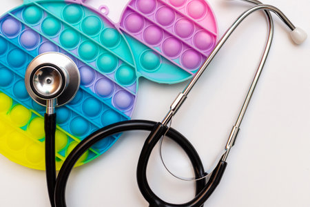 Trendy Silicone sensory toy antistress pop it. Rainbow anti stress toy fidget and stethoscope on white background.Top view.の写真素材