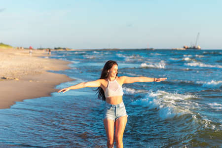 Young woman playing in the sea in summer. woman enjoying in sea water.Cheerful young woman having fun on the beach. She is relaxed in the sea water and enjoys on vacation.の写真素材
