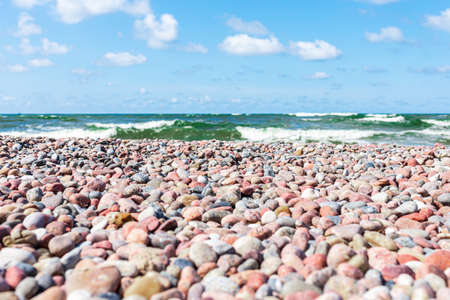 Small pebbles on the shore. sunny summer day blue sky,white clouds. beautiful lonely small pebble beach.Copy space.の写真素材
