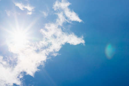 Shining sun at clear blue sky,clouds.Solar lens flare. copy space.Natural lens flare.の写真素材