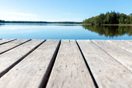 Pier on the lake.Wooden bridge forest in spring autumn time with blue lake. Lake for fishing with pier.Copy space.の写真素材