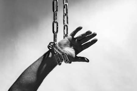 Hand with chain hang,chain in hand,the chain wound on the hand,gray background.Copy space.の写真素材