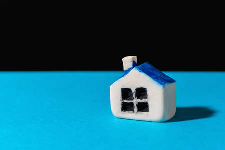 Miniature toy house stand on the blue,black background.Indoors shot.Home insurance concept.Copy space.の写真素材