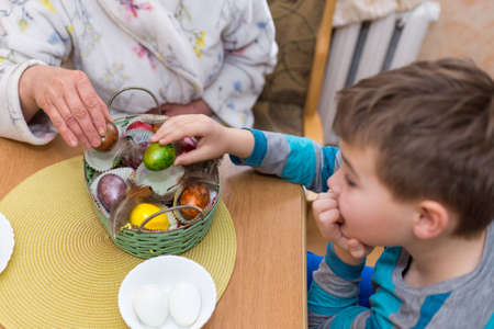 9 year old boy, mother having fun with Beating Easter eggs, traditional action in Lithuania for Eastern holidayの写真素材