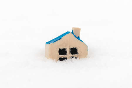 Miniature toy house on the snowdrift.business disaster,natural disaster,Home insurance concept.Copy...