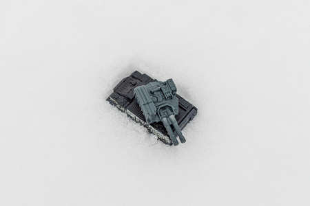 Miniature toy war tank on the winter snow.Selective focus,copy space.Outdoors shot.Top view.の写真素材