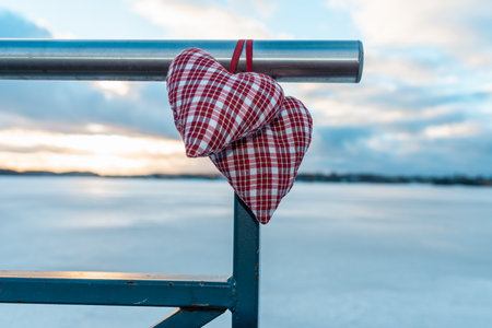 Two Valentine s hearts cloudy sunset blurred background against winter landscape.Valentine s Day Concept.の写真素材