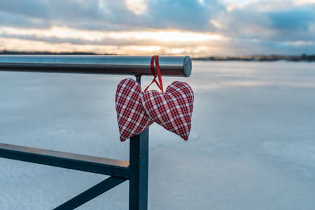 Two Valentine s hearts cloudy sunset blurred background against winter landscape.Valentine s Day...