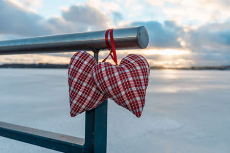 Couple Valentine s hearts cloudy sunset blurred background against winter landscape.Valentine s Day Concept.の写真素材