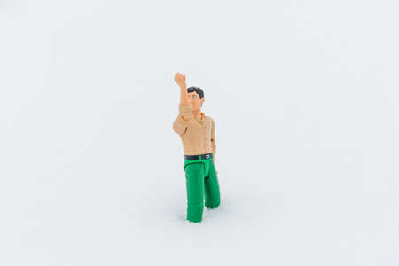 Miniature toy man holding something, white snow background.copy space.Outdoors shot.の写真素材