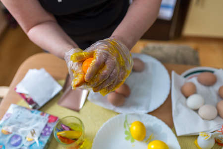Easter egg painting.woman coloring easter eggs in the kitchen at home.