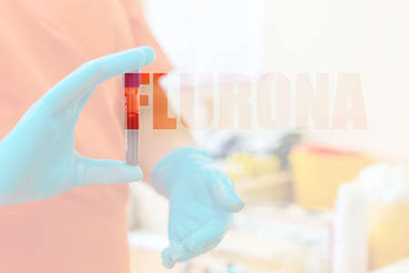 Inscription Flurona Coronavirus infection Covid-19 and flu. Text and lab or laboratory.Scientist holds tube blood sample vacuum flask.Selective focus.Double exposure.の写真素材