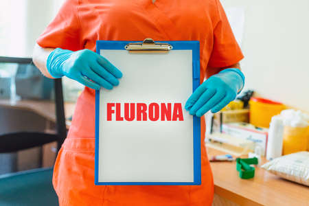 Inscription Flurona Coronavirus infection Covid-19 and flu. Text and lab or laboratory.Scientist holds inscription.Selective focus.の写真素材