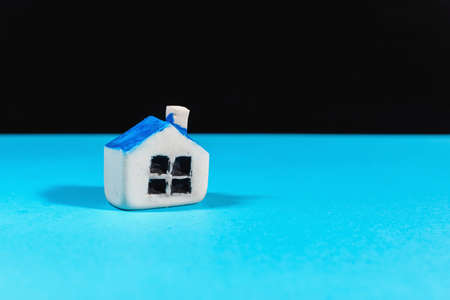 Miniature toy house stand on the blue,black background.Indoors shot.Home insurance concept.Copy space.の写真素材