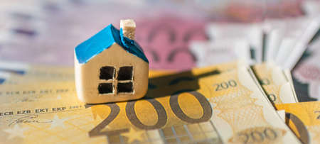Miniature toy house lie on the euro money cash backround.Banner,panoramic view,selective focus.の写真素材