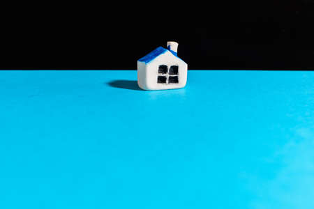 Miniature toy house stand on the blue,black background.Indoors shot.Home insurance concept.Copy space.の写真素材