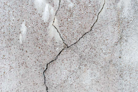 Cracked concrete wall gray cement surface background.cracked grey stone wall in winter.close-up.