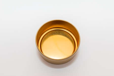 Yellow golden round empty metal box on white background.Soft focus,top view,copy space.の写真素材