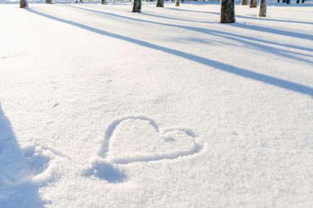 Nice heart shape on the fresh snow winter lanscape,park or forest.の写真素材