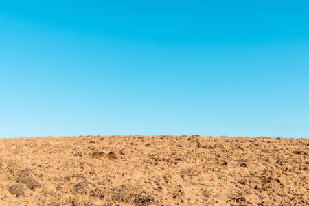 Beautiful agricultural rural background,spring landscape.Blue clear sky background. Plowed field in the foreground.Copy space.Closeup.の写真素材