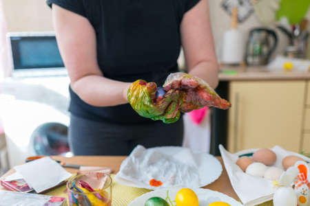 Easter egg painting.woman coloring easter eggs in the kitchen at home.の写真素材