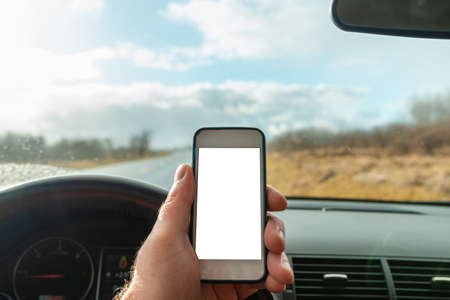 Man using blank white screen mobile smartphone inside a car in spring day landscape. copy space for your advertisement,mockup.の写真素材