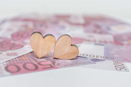 Two hearts flat lay on the 500 five hundred cash money pile paper blurred background.Selective focus,copy space.の写真素材