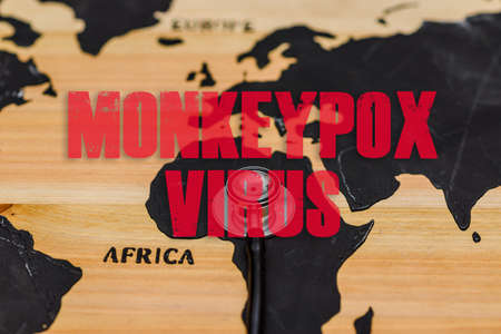 Monkeypox outbreak.Monkeypox is caused by monkeypox virus.Virus transmitted to humans from animals.Inscription world wooden map,a stethoscope lie on the map.の写真素材