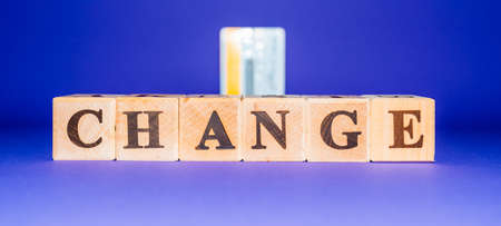 Word Change spelled on wooden dices and credit card over purple, veri peri background.Banner.