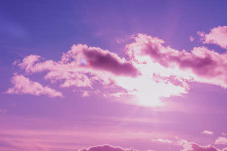 Beautiful pink,purple sunset cloudy sky evening.Landscape,sun sunrays through the white clouds.Toned.の写真素材