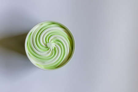 Ice cream in the paper cup on a white,gray background, top view.soft focus whipped ice cream standing on a paper background.Copy space.の写真素材