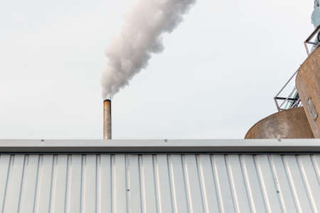 Chemical factory,smoke stack,CO2 greenhouse gas emissions coming from the smoking chimney pipe.Cloudy blue sky background.Copy space.の写真素材