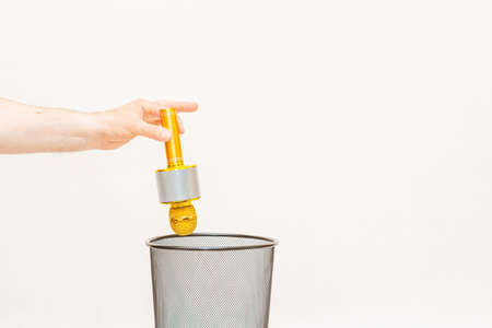 The yellow karaoke microphone is thrown into the trash for recycling.White,gray background,selective...
