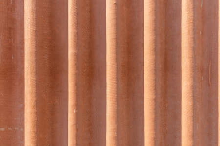Corrugated red asbestos roof.A fragment of a roof background.