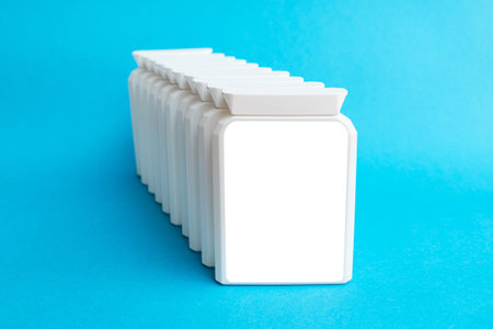 White blank mockup for ad. Pharmaceutical supplement plastic box on blue background.の写真素材