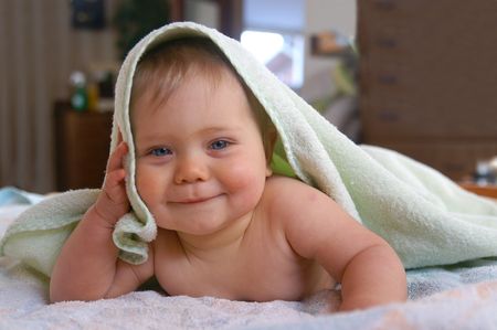 Child 9 month. Child curled to towels after bath の写真素材
