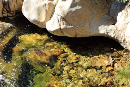 Large boulder overhanging riverの写真素材