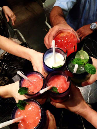 Hands holding drinks for celebrationの素材