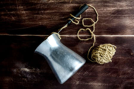 Rustic still life: old cezve with twine on a wooden tableの写真素材