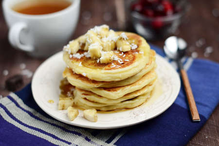 Cottage cheese pancakes with banana, coconut and maple syrup.の写真素材