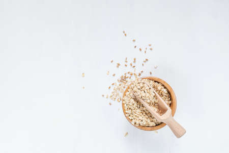 Rolled oats in bowl on white table, top view. Copy spaceの写真素材