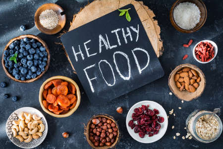 Healthy foods, super foods in bowls and jars on dark background. Assortment foods. Top viewの写真素材