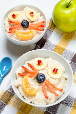 School kid breakfast. Oatmeal porridge with animal face, food for kids. Funny creative breakfast for childrenの写真素材