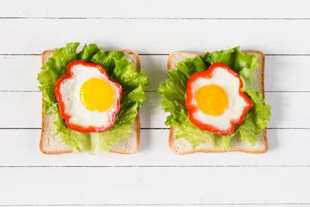 Breakfast sandwich with egg, cheese and green salad. Top view healthy food. Creative food ideas