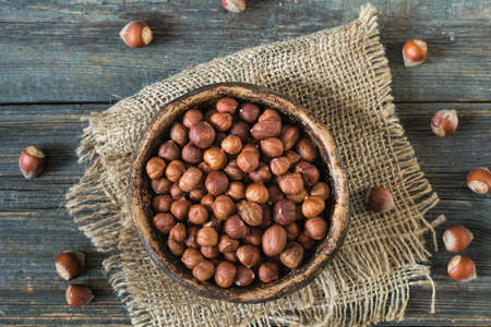Raw hazelnuts in bowl on linen cloth. Food ingredients for healthy life. Overhead view.の写真素材