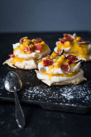 Pavlova pastry with lemon curd, fresh figs and poppy seed. Vertical, selective focusの写真素材