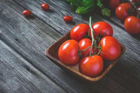 Tomatoes on vine in bowl. Rustic composition. Soft selective focus