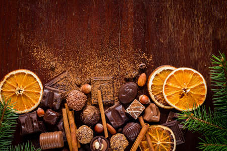 Christmas sweets, chocolates, spices, chocolate truffles and dried oranges on wooden backgroun with copy space for text. Horizontalの写真素材